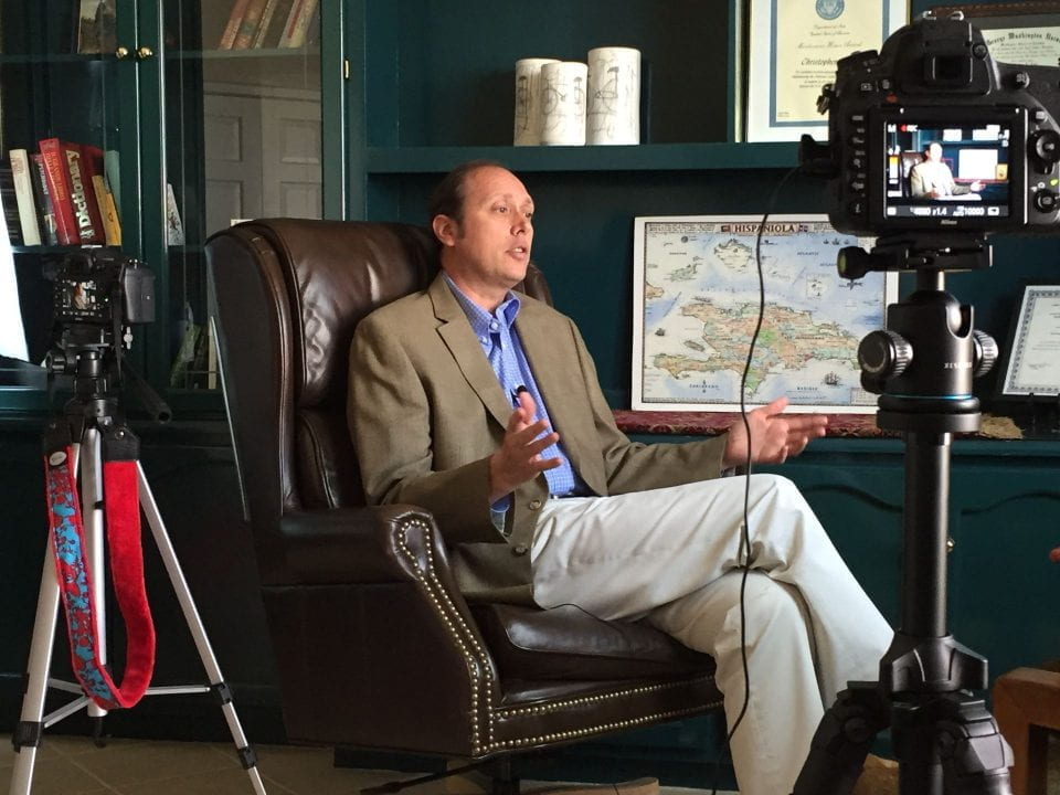 Christopher Teal speaks on camera while seated